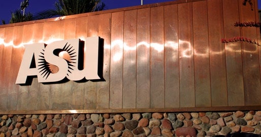 A large copper and stone sign that features the ASU sunburst logo. 