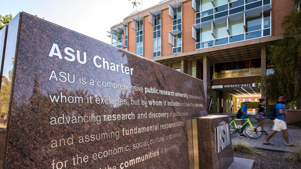 A stone monument inscribed with a university charter statement sits on campus as a reminder of the institution's commitment to advancing access, excellence and impact. 