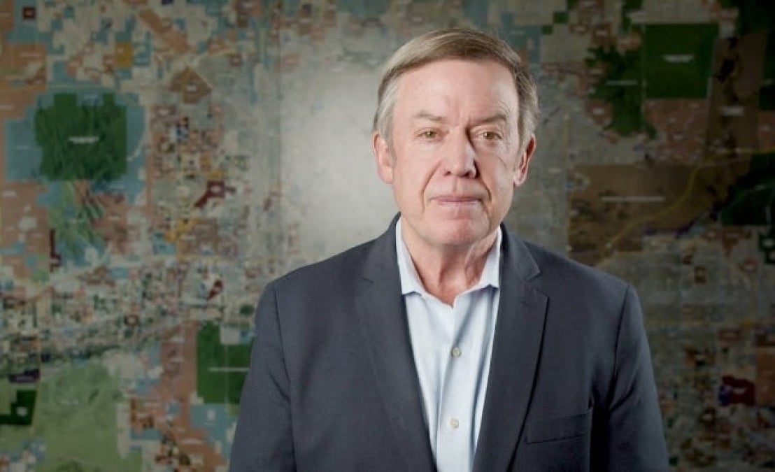 Michael Crow stands in front of a valley map in the Fulton Center. 