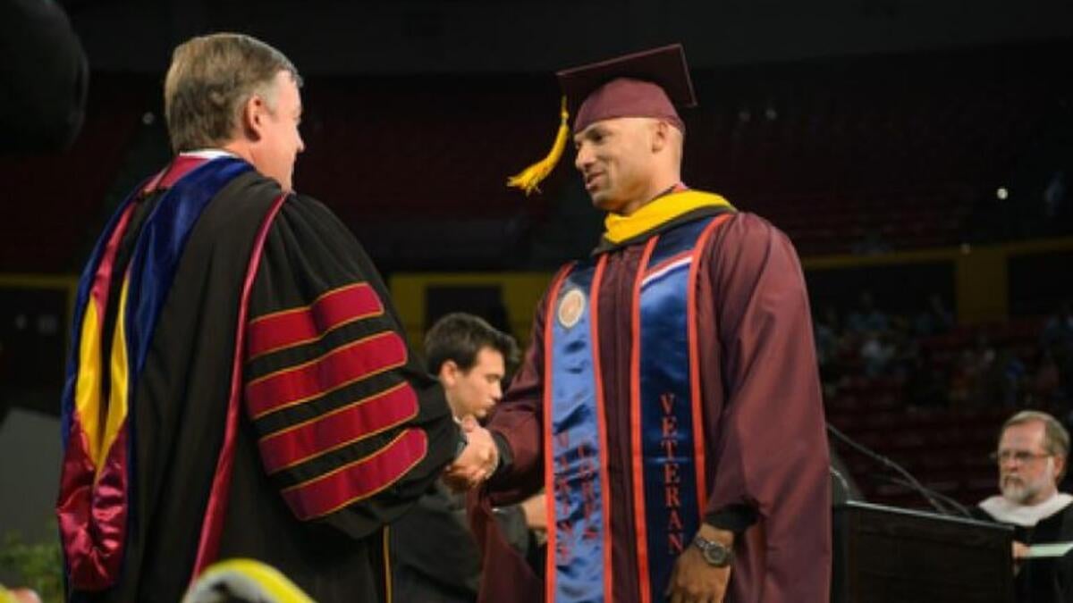 ASU President Michael Crow congratulates a student veteran during Graduate Commencement at Wells Fargo Arena  