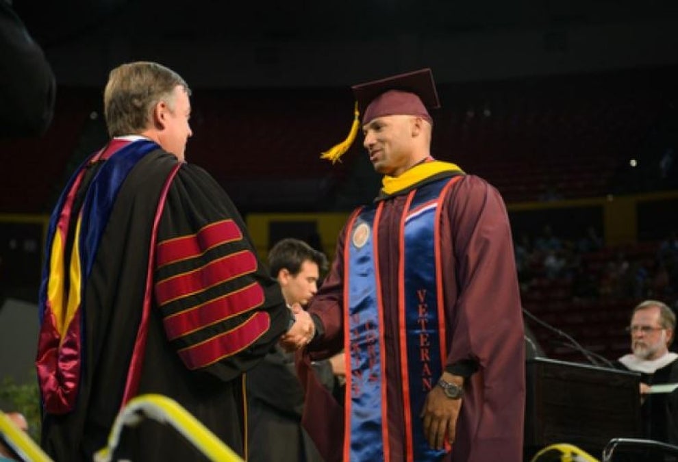 ASU President Michael Crow congratulates a student veteran during Graduate Commencement at Wells Fargo Arena