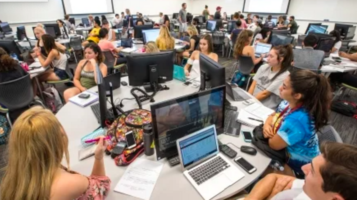College students study around a round table in a university video. 